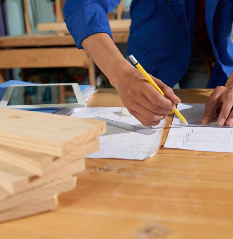 Cropped image of carpenter drawing a furniture piece