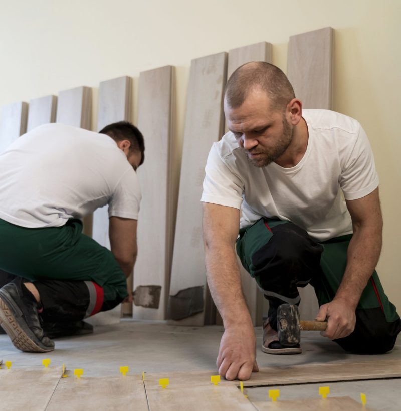 full-shot-workers-tiling-floor-indoors