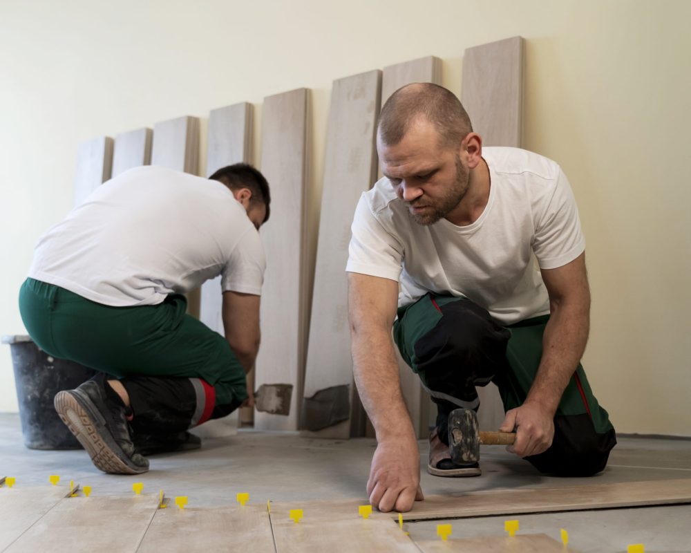 full-shot-workers-tiling-floor-indoors
