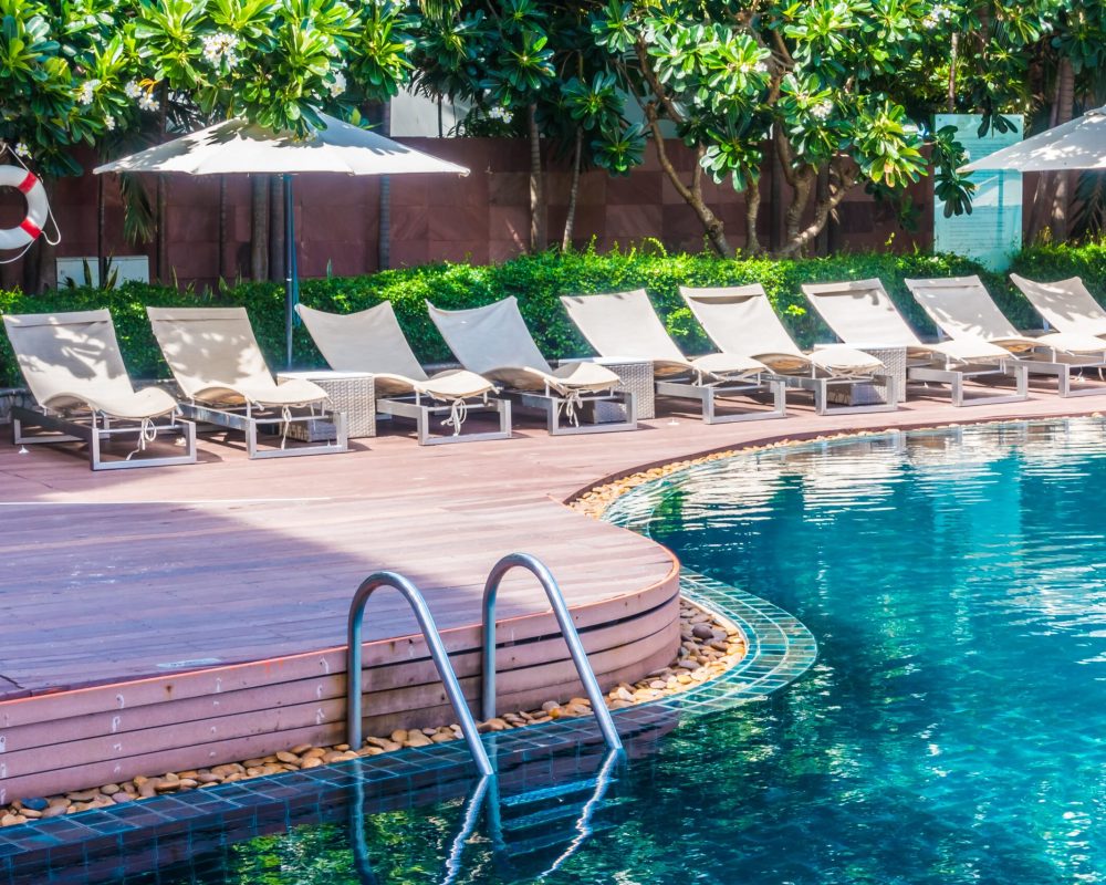 Umbrella and chair around beautiful luxury outdoor swimming pool in hotel resort