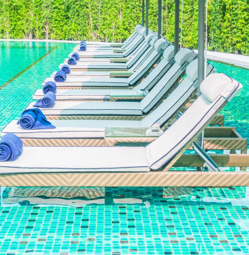 Umbrella and chair around swimming pool in hotel pool resort